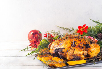 Christmas and Thanksgiving traditional baked chicken. Whole roasted chicken for holiday dinner, with oranges and thyme, on Christmas or Thanksgiving decorated table