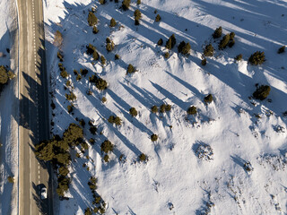 Scenic winter drive: A road winds through Andorra's snow-covered mountains, a captivating alpine landscape.