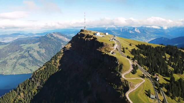 Panoramic Aerial View of Alpine Mountain Massif with High-Altitude Funicular Train and Satellite Towers Above Rigi Kulm Peak, Overlooking Lake Zugersee and Grosser Mythen in Switzerland"
