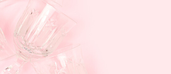 Banner with crystal glasses on a pink background. Concept with copy space.