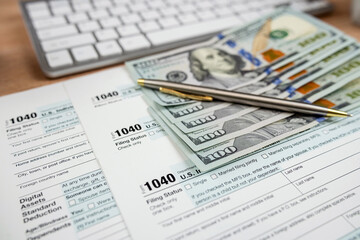 Obraz premium Tax payment with 1040 form pen and dollar bills