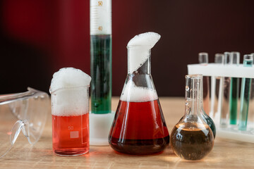 Glass laboratory flask and beaker with liquids for analys or experiment in desk