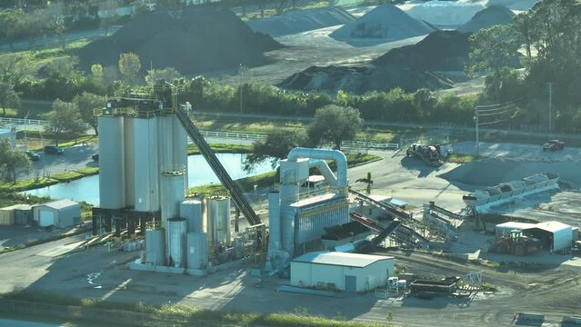 Aerial view of concrete mixing factory at industrial area with cement trucks and heavy building equipment