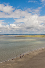 Lagoon at low tide with wonderfull clouds as seen from Mont-Saint-Michel abbey. Vertical shot. Normandy, France