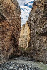 Fototapeta na wymiar A fast mountain river flows into a mountain gorge