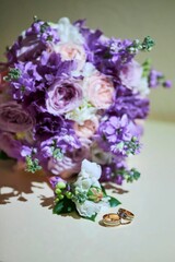 Two wedding rings on the table next to a bouquet of flowers, a wedding celebration