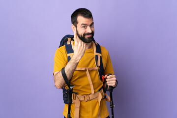 Caucasian handsome man with backpack and trekking poles over isolated background doing coming gesture