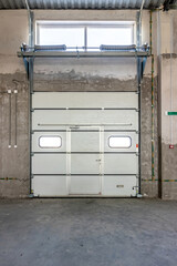 Row of overhead sectional doors in a multi-seat car garage. Inside view