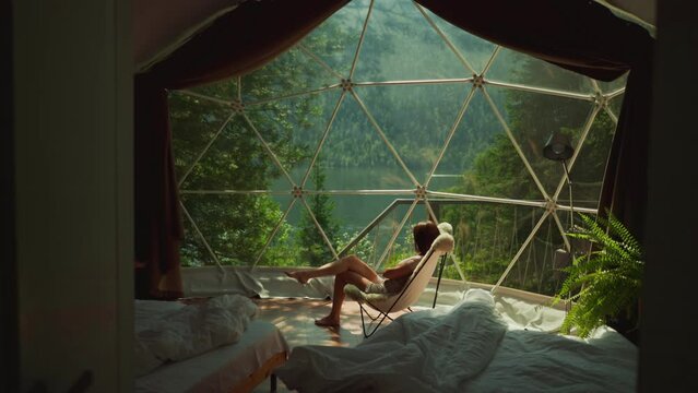 Female enjoys breathtaking view from cottage bedroom window