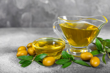 Olive oil in a bottle on texture background. Oil bottle and a bowl with branches and fruits of olives. Place for text. copy space. cooking oil and salad dressing.