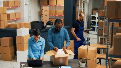 Employees putting products in boxes and dong highfive, celebrating stock shipment and delivery. Team of people working on retail development, shipping merchandise in packages.
