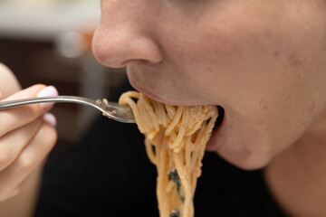 Mouth eats spaghetti. Close-up shot of the eating process