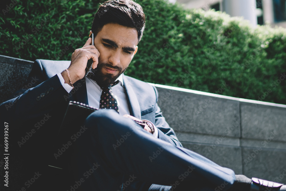 Poster man in formal suit talking with employee about data report