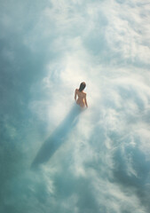 Naked Woman Standing in Dreamlike Cloud Expanse - Eliciting Sensations of Solitude & Ethereal Introspection.