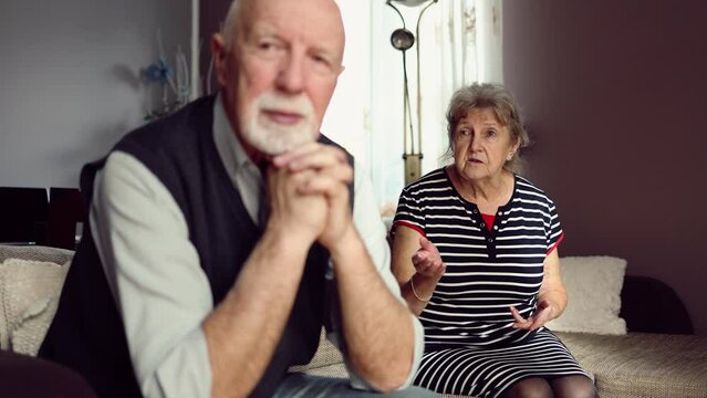 Elderly couple arguing while sitting on the sofa at home
