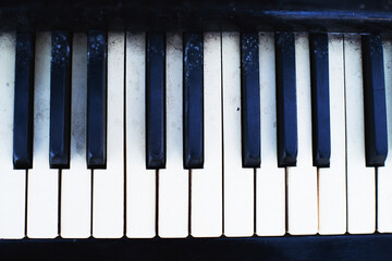 Black and white keys of an old piano close-up, soft selective focus. Old retro musical keyboard instrument