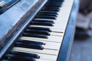 Black and white keys of an old piano close-up, soft selective focus. Old retro musical keyboard instrument
