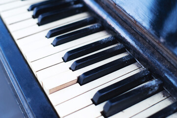 Black and white keys of an old piano close-up, soft selective focus. Old retro musical keyboard instrument