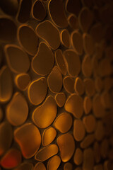 Dark golden metal surface in form of flat smooth pebbles 