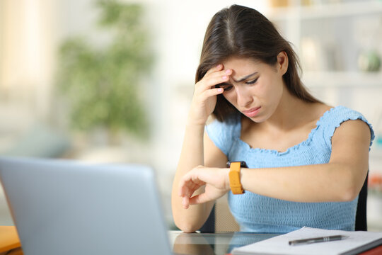 Worried student checking smartwatch at home