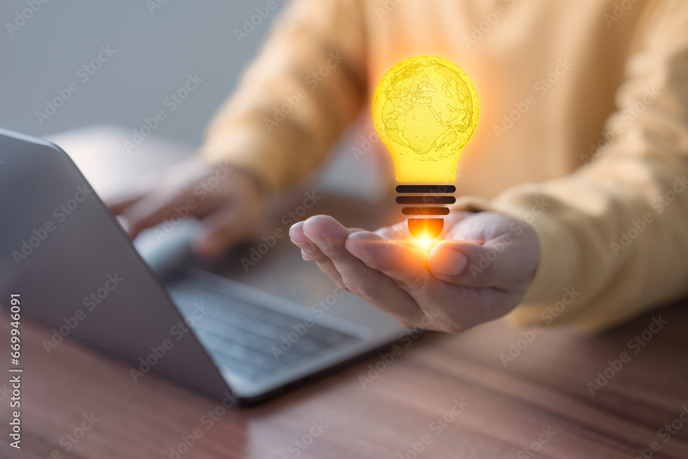 Poster abstract light bulb on hand while working on a computer laptop to think and generate new ideas throu