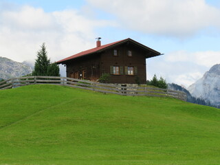 Obraz premium Berghütte auf eine Wiese in den Alpen