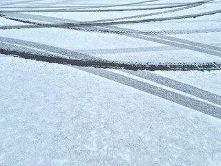 Dynamic car tread marks on the snow. Early winter. Energy and expression of movement. Black and...