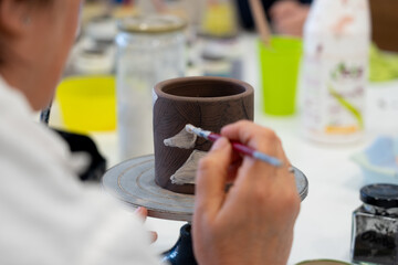 Woman decorating a ceramic vase