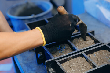 Worker making cube concrete casting by steel mould for control quality cement in building lab