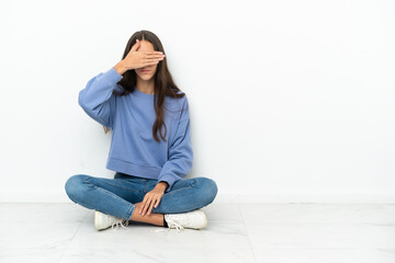 Young French girl sitting on the floor covering eyes by hands. Do not want to see something
