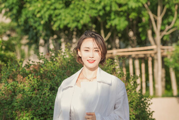 Fototapeta premium 대한민국 서울의 한 공원에서 미소를 짖고 있는 한국인 젊은 여성