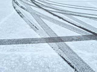 Dynamic car tread marks on the snow. Early winter. Energy and expression of movement. Black and...