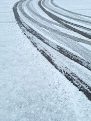 Dynamic car tread marks on the snow. Early winter. Energy and expression of movement. Black and...