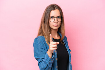 Young caucasian woman isolated on pink background frustrated and pointing to the front