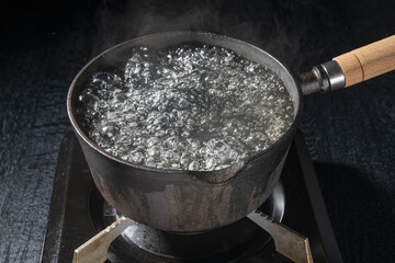 鉄鍋で沸騰したお湯を沸かすシーン