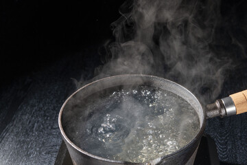 鉄鍋で沸騰したお湯を沸かすシーン
