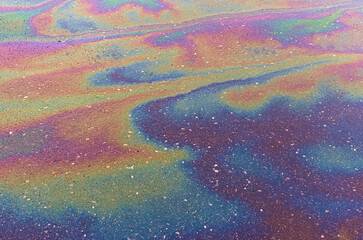 Spills of fuel or oil on the asphalt road as texture or background