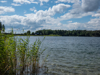 Landscape of lake and forest in the far and texture of crystal clear light Blue, green and turquoise transparent water with fine white sand base