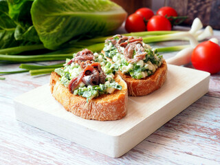 Cottage Cheese and Anchovy Bruschetta Close-Up on a White Board