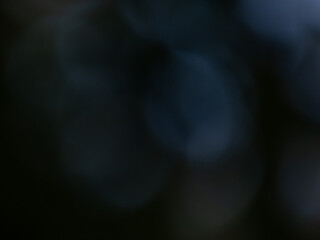 Black and dark blue bokeh effect and purposely blurred view. Dark background with photographic bokeh effect