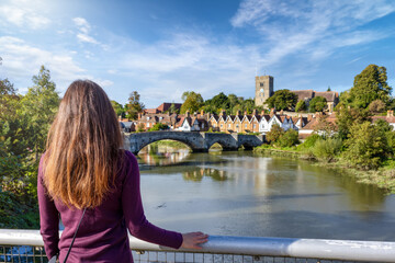A tourist woman enjoys the view of beautiful landscape of Kent, England, with Aylesford village and...