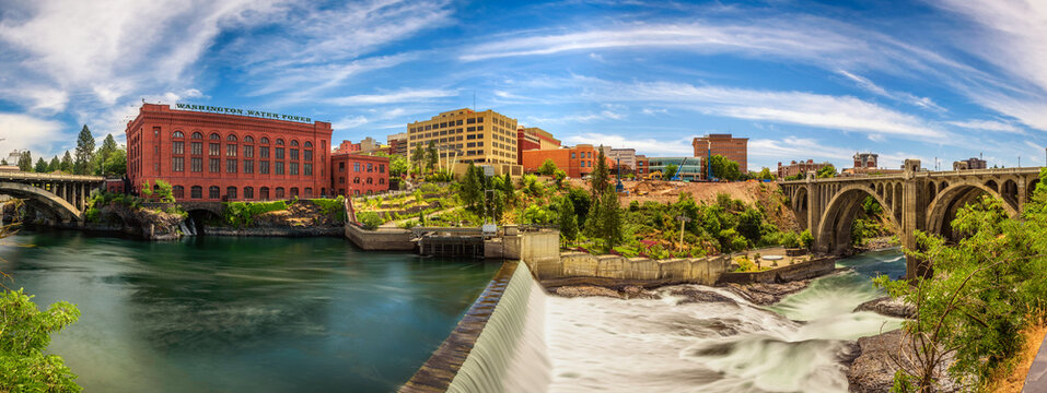 SPOKANE, WASHINGTON, USA - JULY 4, 2017 : Panoramic cityscape view of Washington Water Power building and the Monroe Street Bridge along the Spokane river, in Spokane, Washington.