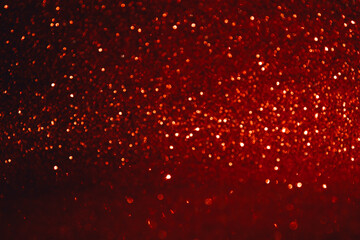 Shining sparkling red blurred background for holiday design. Christmas abstract sparkles, selective...
