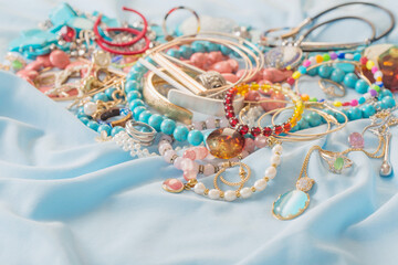 different women's jewelry on blue fabric