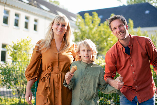 Happy parents with son holding ice cream cone on sunny day