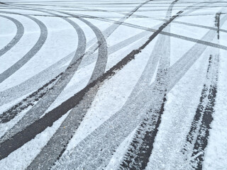 Dynamic car tread marks on the snow. Early winter. Energy and expression of movement. Black and...