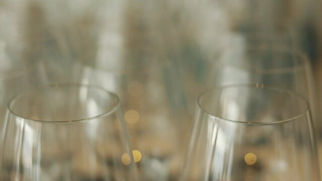 In the elegant setting of a fine dining restaurant, this shows rows of empty crystal-clear wine glasses, beautiful symbol of luxury and refinement, glassware await in shaping a memorable party.