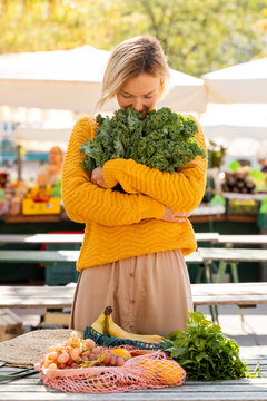 Woman smelling kale at farmer's market