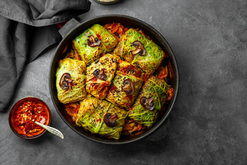 Savoy cabbage stuffed with mushrooms top view, vegetarian dish, gray background copy space