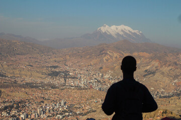 homem com montanhas nevadas da cordilheira dos andes ao fundo 
